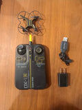 Black quadcopter micro drone with yellow accents, remote controller, USB cable and charger
