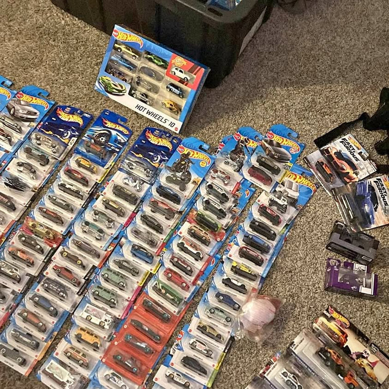 Hot Wheels diecast model car lot with multiple blue blister packs and vehicles