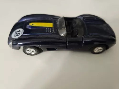 Diecast roadster convertible toy car in dark blue, side view with yellow detail