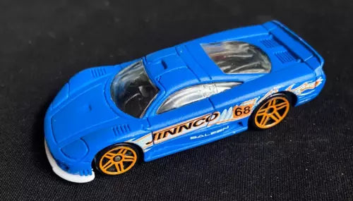 Blue diecast sports car with gold wheels and decals, front three-quarter view