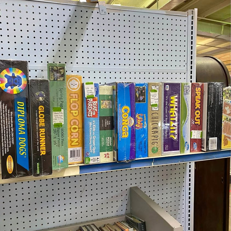 Assorted boxed board games and collectible trading card packs on display rack