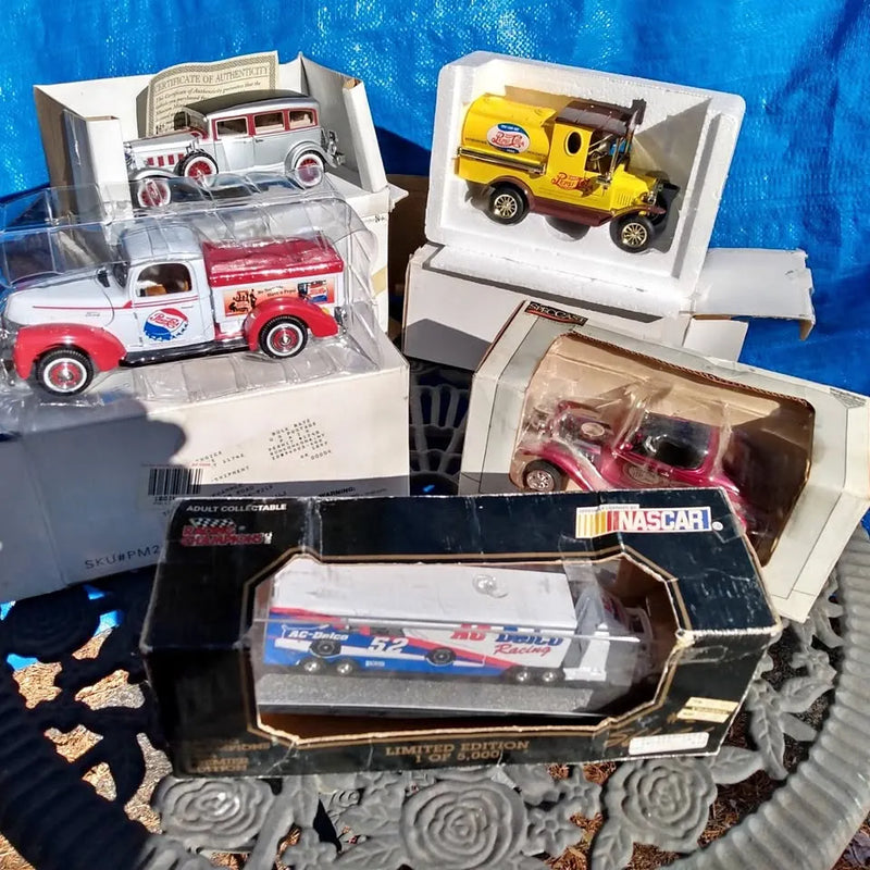 Assorted ERTL diecast trucks in clear display boxes, including red and yellow trucks