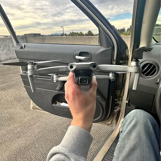 Drone remote controller held in hand, gray casing and screen