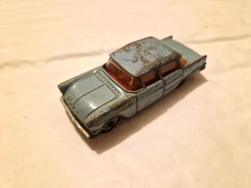 Vintage diecast model car, metallic gray with red interior and worn clear windows