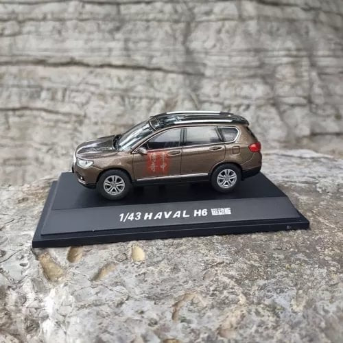 1:43 scale diecast SUV model car, brown, side view on display base