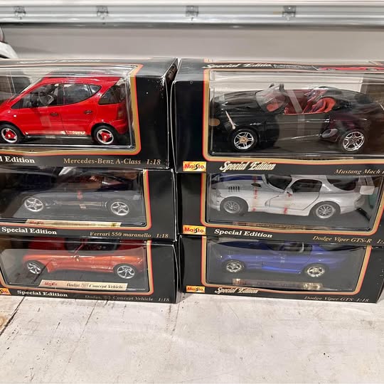 Assorted 1:18 diecast car models in four display boxes with clear windows