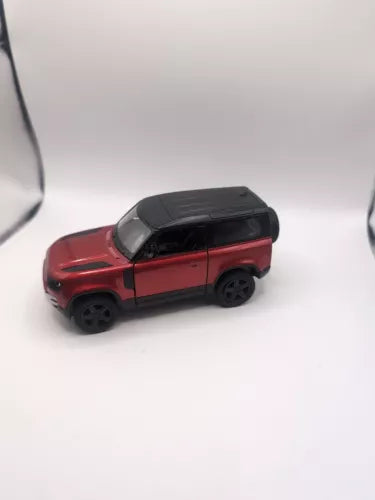 Red diecast Land Rover Defender 90 toy SUV with black roof, side view