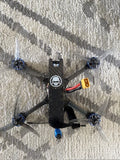 Black FPV quadcopter drone with four propellers and central camera module