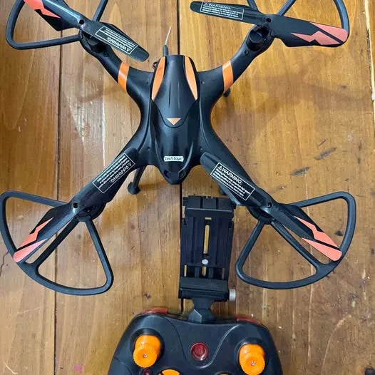 Black quadcopter drone with orange indicator lights and four propellers