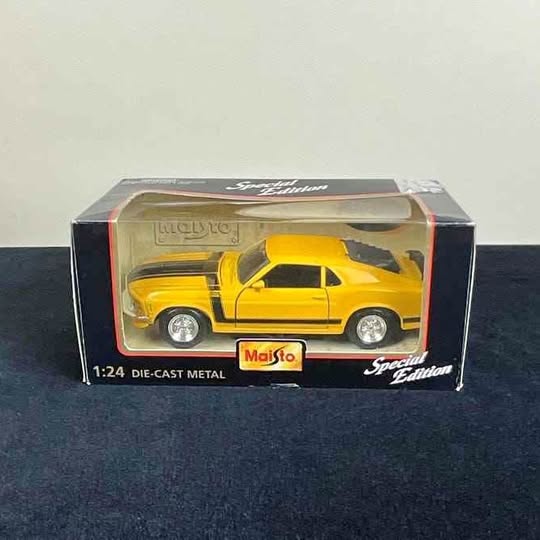 Yellow 1:24 die-cast car model in retail box, Mustang-style coupe
