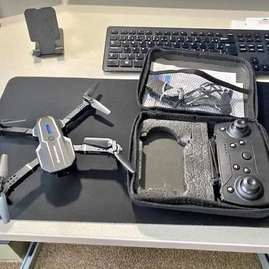 Foldable quadcopter drone with open storage case and control components