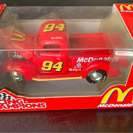 Red diecast race car with #94 McDonald's logo, in retail display box.