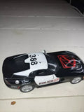 Black and white police diecast model car, #388, red emblem on hood, 1:36 scale