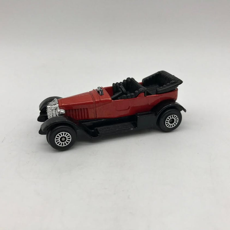 Red vintage diecast toy car with black wheels and tires