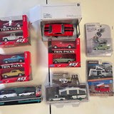 Diecast car and truck set in twin-pack boxes with red, green, and camper vehicles