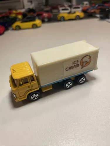 Vintage diecast ice cream truck with yellow cab and cream box labeled Ice Cream