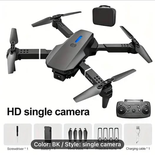 Gray quadcopter drone with 4 propellers, attached camera, and handheld remote controller