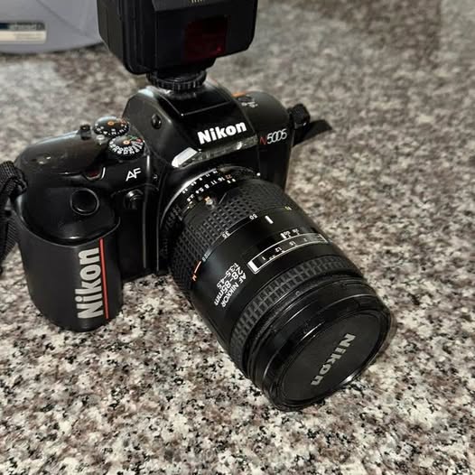 Nikon N5005 camera with attached Nikkor lens, black body