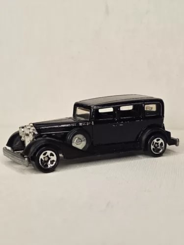 Hot Wheels 1982 Packard diecast car, black side view with 5-spoke chrome wheels