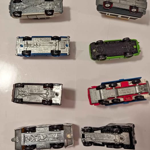 Super Tomica diecast vehicles, assorted metallic and dark colors, multiple angles