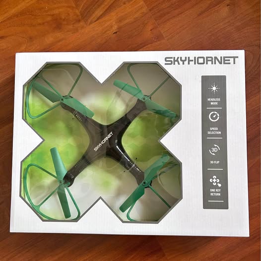 SkyHornet drone in box, showing four green propellers and remote control features