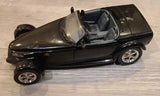 Dark diecast sports car with open cockpit and silver wheels, 1:24 scale