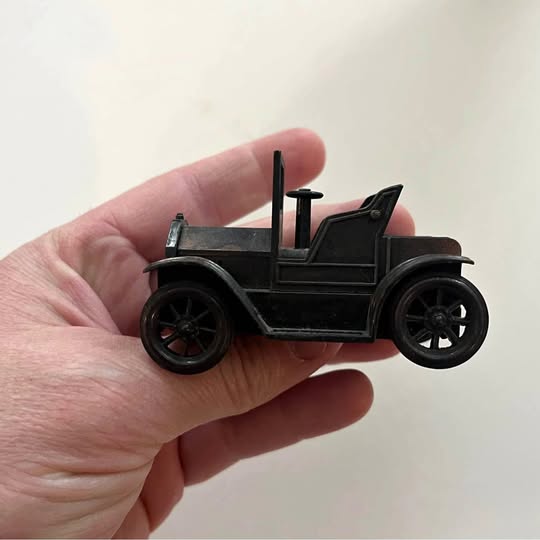 Diecast model T car pencil sharpener, dark metal car with upright blade