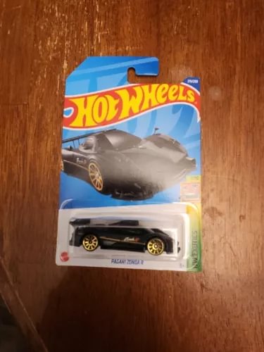 Black diecast toy car in blister pack, front view with wheels visible