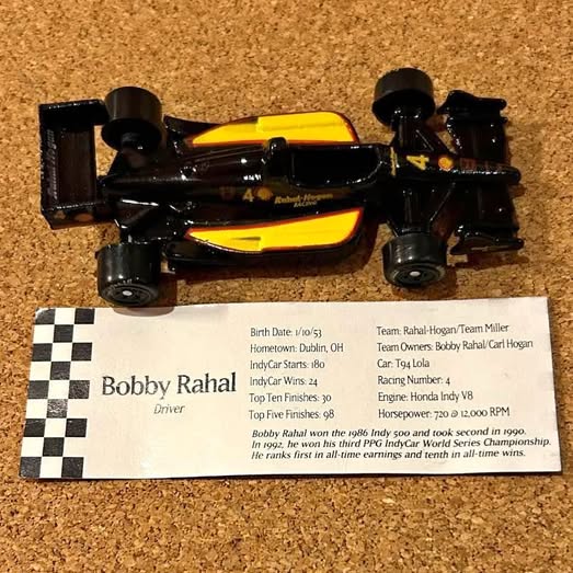 Diecast race car, black with yellow stripes and number 4 on the side
