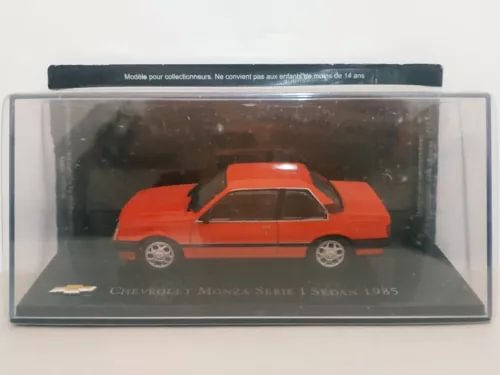 Orange 1980s diecast sedan model in display box, side profile