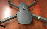 Gray quadcopter drone with four propellers, front camera pod and Mavic branding