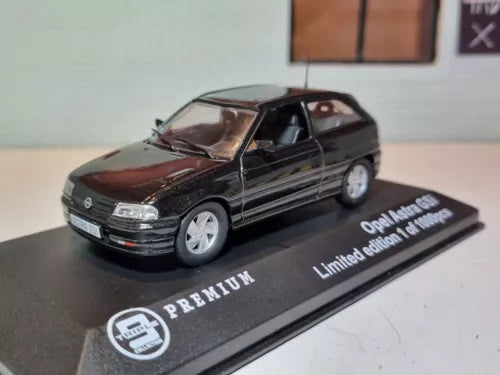 Black diecast model car with silver wheels on branded display base