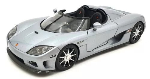 Silver diecast sports car model with open cockpit and five-spoke wheels, front three-quarter view