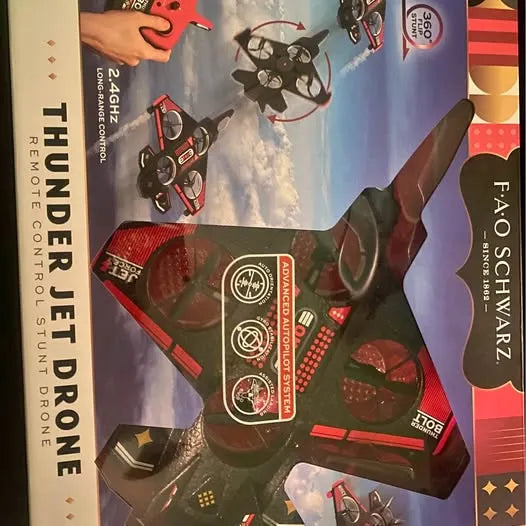 Toy drone in retail packaging, black and red with blue accent panel