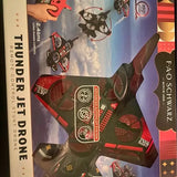 Toy drone in retail packaging, black and red with blue accent panel