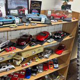 Diecast model car display with multiple classic cars on wooden shelves