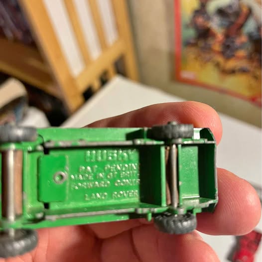 Green diecast model car with wheels, side close-up