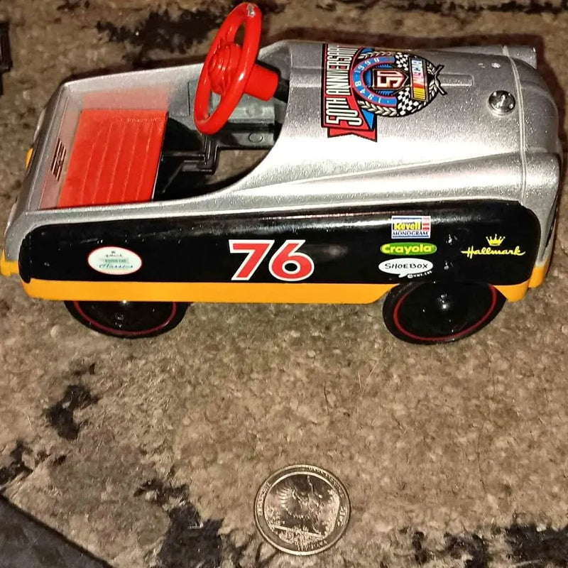 Diecast car with silver body, red wheels, and #76 graphic on side.
