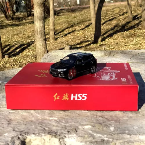 Black diecast SUV model on red display box with front grille and headlights visible
