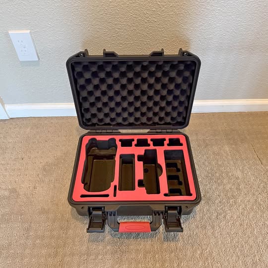 Waterproof drone case with foam inserts, open lid, black shell and red interior
