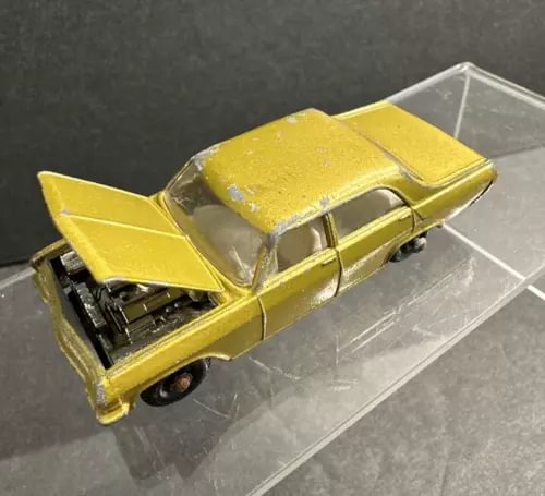 Lesney Matchbox vintage diecast car with yellow body and open hood, chrome engine detail