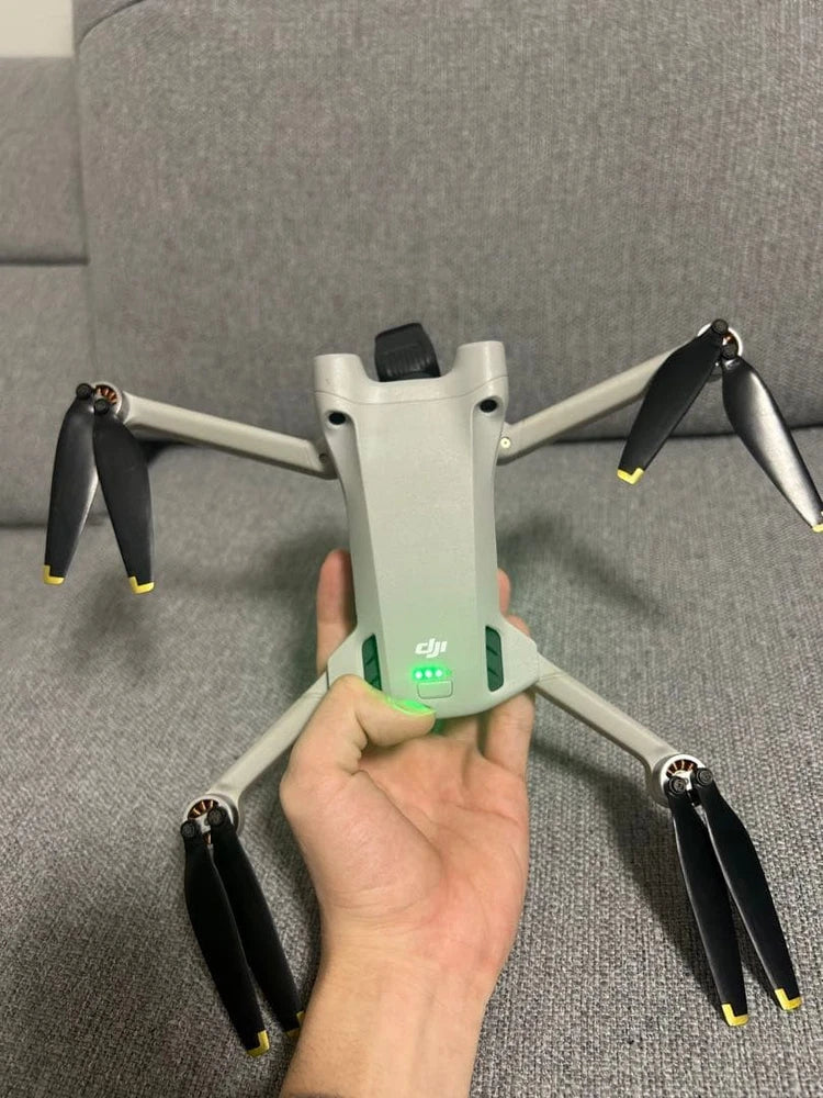 Dji Mini 3 Pro drone held in hand, white quadcopter with four propellers