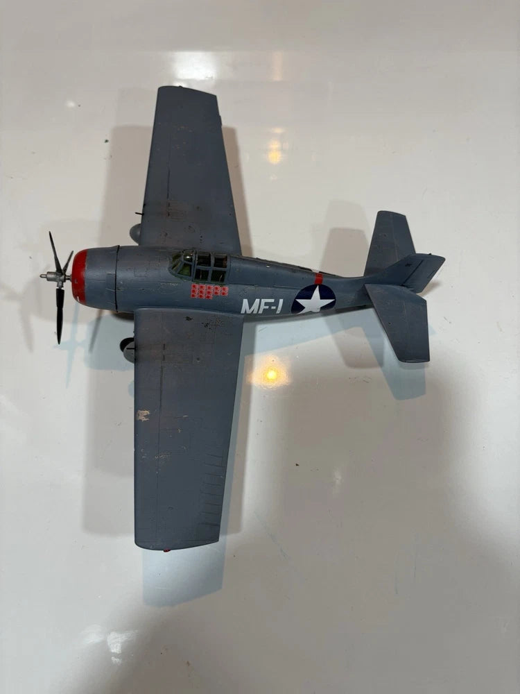 Weathered F4F Wildcat model airplane in dark gray with US star insignia