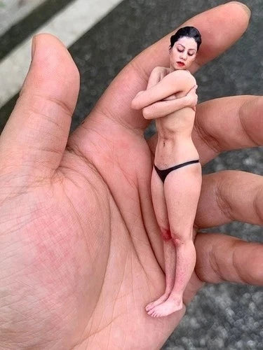Miniature resin figurine of a female figure in black bikini bottom, hugging pose