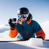 White action camera in a skier's hand, with lens facing forward