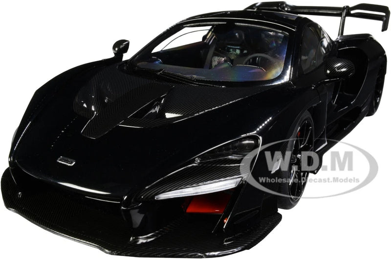 1:18 scale black model car with carbon-fiber accents, front three-quarter view