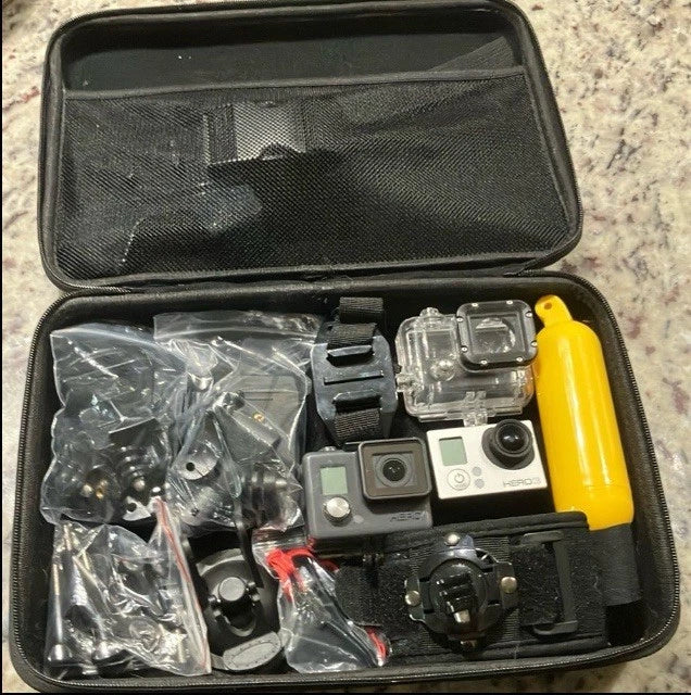 GoPro action camera accessories kit in black hard case with camera, mounts, and housing