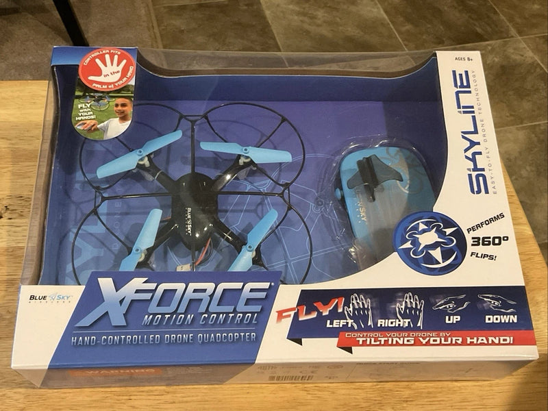 Hand-controlled quadcopter drone box with blue propellers and XFORCE Motion Control graphics