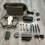Drone kit with controller, batteries, propellers, and carrying bag