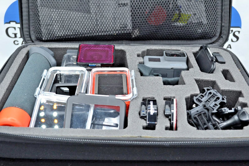 Action camera accessories in open hard case with mounts, camera housing, and screen